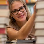Smiley woman is touching books