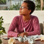 Black young woman in glasses is thinking about something